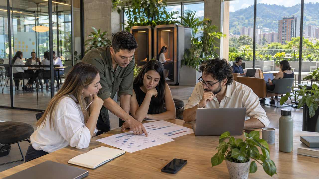 Equipo híbrido revisa un calendario de asistencia en un coworking de Ciudad del Río